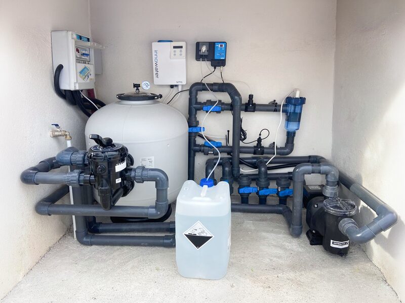 Sala técnica de piscina con filtro de arena, bomba, clorador salino y control de pH