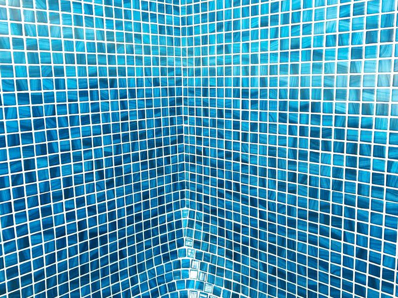 Vaso de piscina revestido con gresite azul tras una renovación